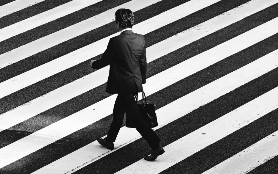 Overhead view of man in suite walking in crosswalk