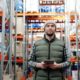 Man in green vest holding a tablet in a warehouse