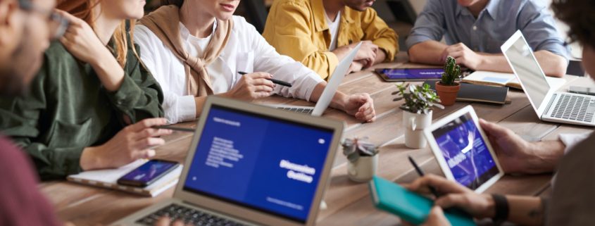 Group at table with devices discussing a document