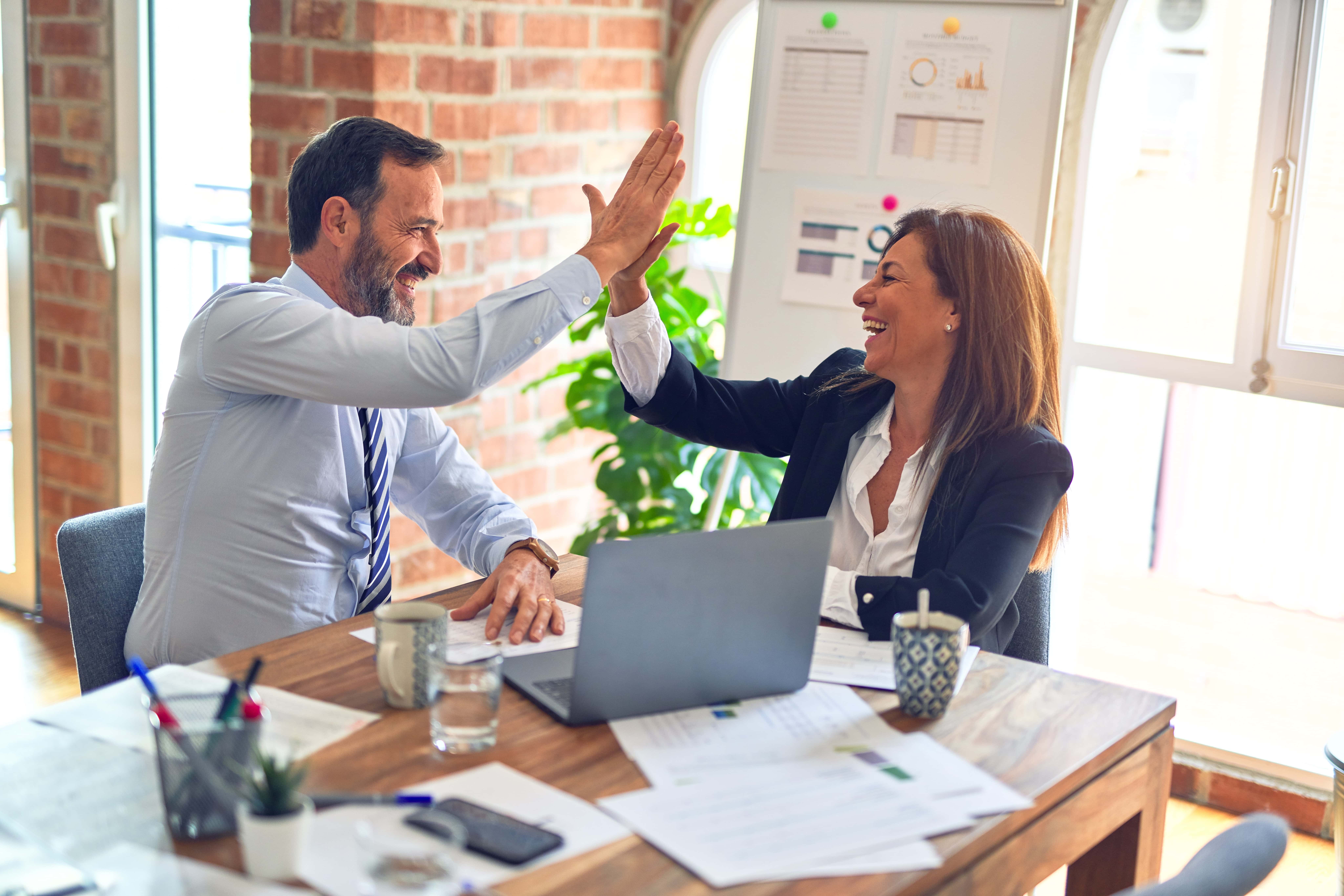 Man and woman high-fiving over a business deal