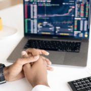 Hands clasped in front of a computer screen and calculator